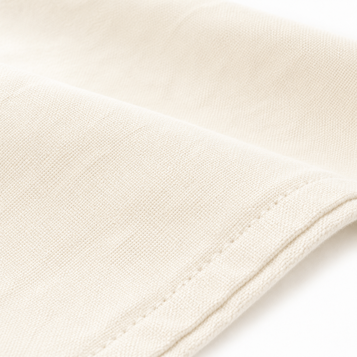 Close-up of warm ivory cotton fabric and tonal stitching
